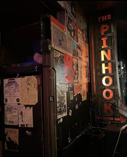 A vertical sign reading "The Pinhook" stands on the wall inside the venue in Durham.