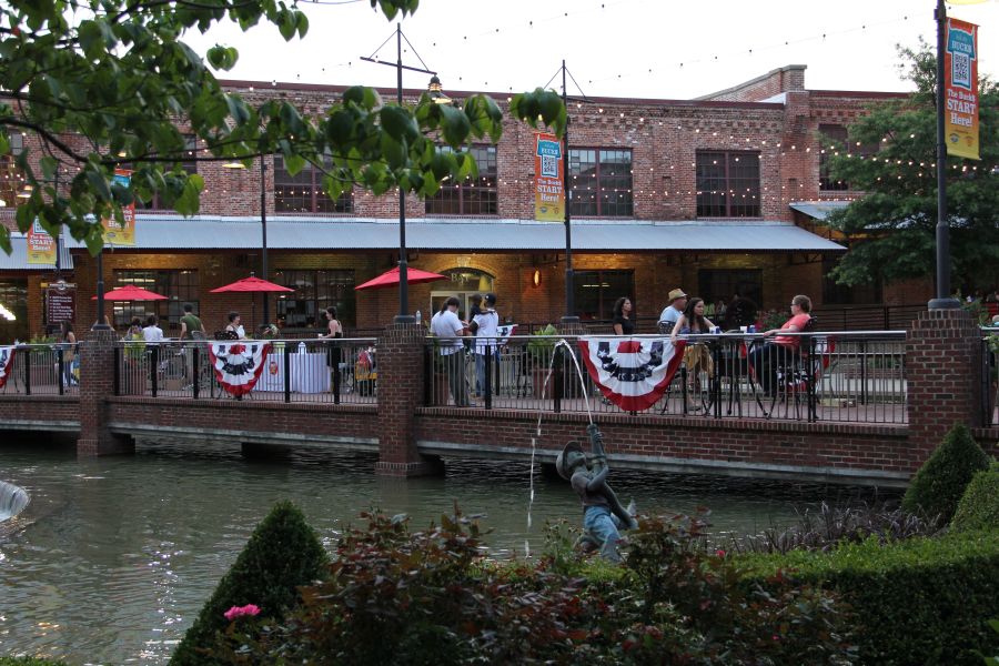 Guests sit near the riverside on the American Tobacco Campus.