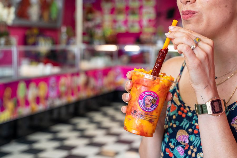A woman sips a mangonada at La Monarca Michoacana in Durham, NC.