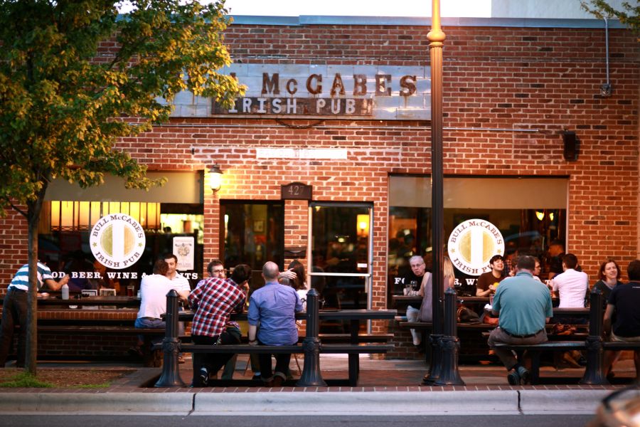 Guests sit outside of Bull McCabe's, socializing on a summer evening.