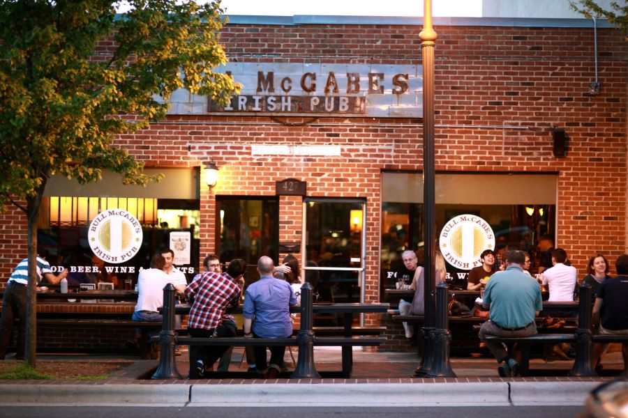 Patrons sit at tables at sunset outside of Bull McCabes in Durham, NC.