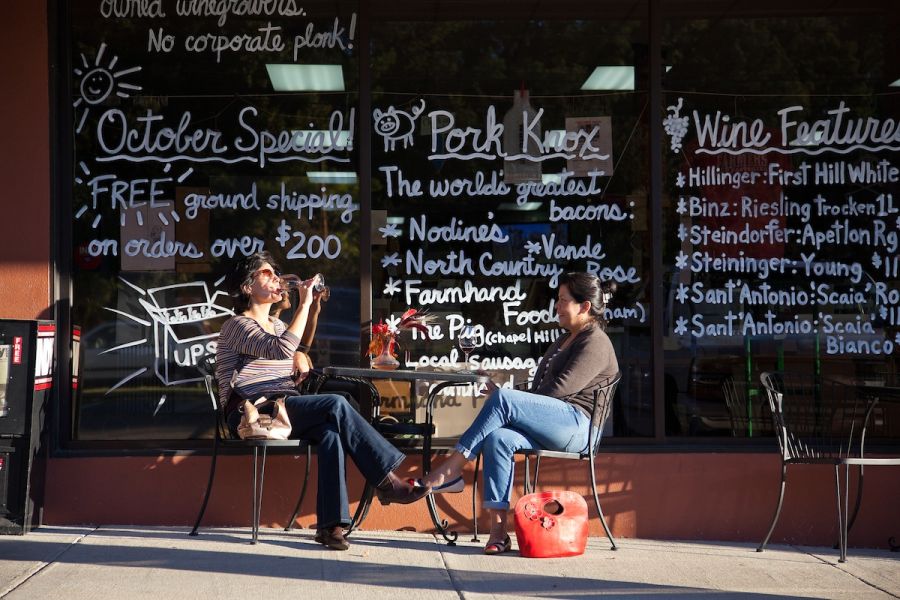 A couple chats in front of Wine Authorities in Durham's Rockwood district.