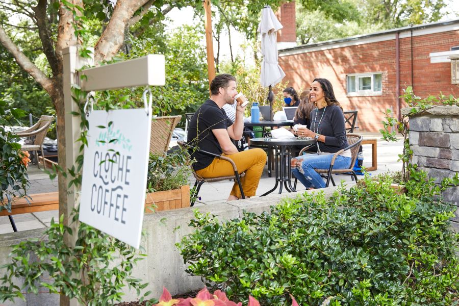 A couple enjoys a coffee on the patio at Cloche Coffee.