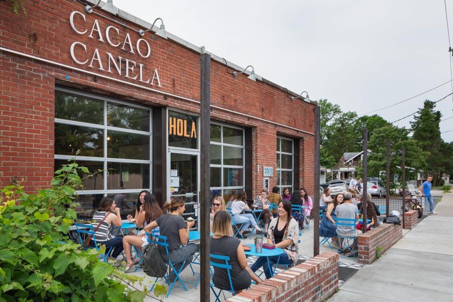 Customers sit on the patio at Cocoa Cinnamon in Old West Durham sipping coffee.