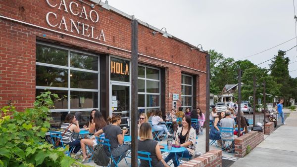 Customers sit on the patio at Cocoa Cinnamon in Old West Durham sipping coffee.