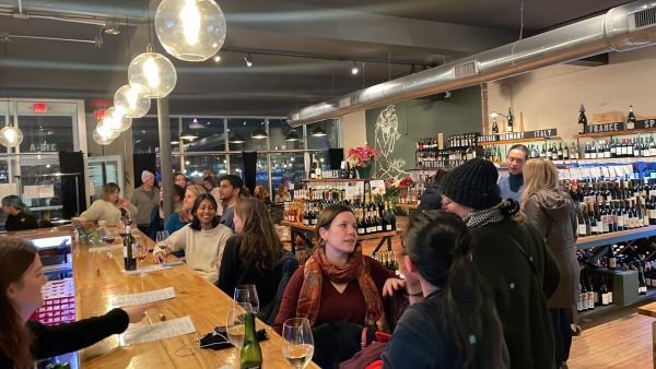Customers sit at the bar socializing at LouElla in Durham, NC.