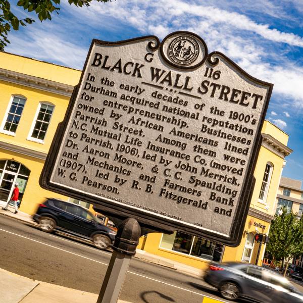 A sign stands on Parrish Street with information about Black Wall Street in Durham.