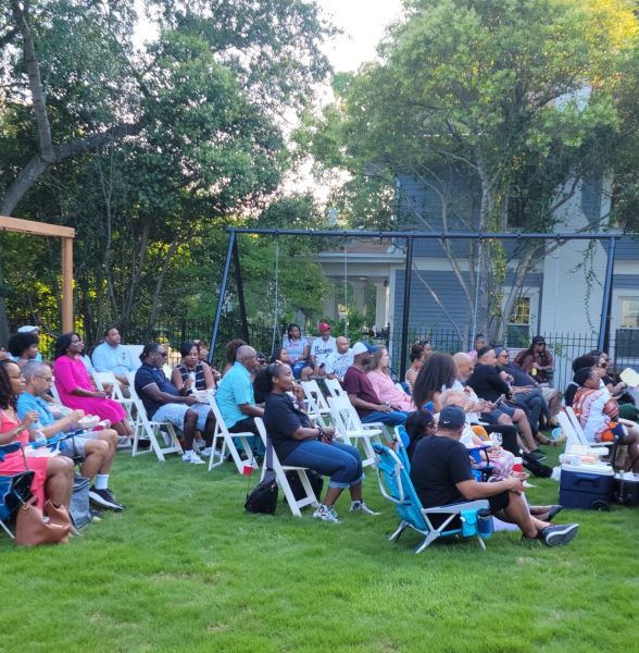 A group of people sit outside in lawn chairs at Morehead Manor Bed and Breakfast.