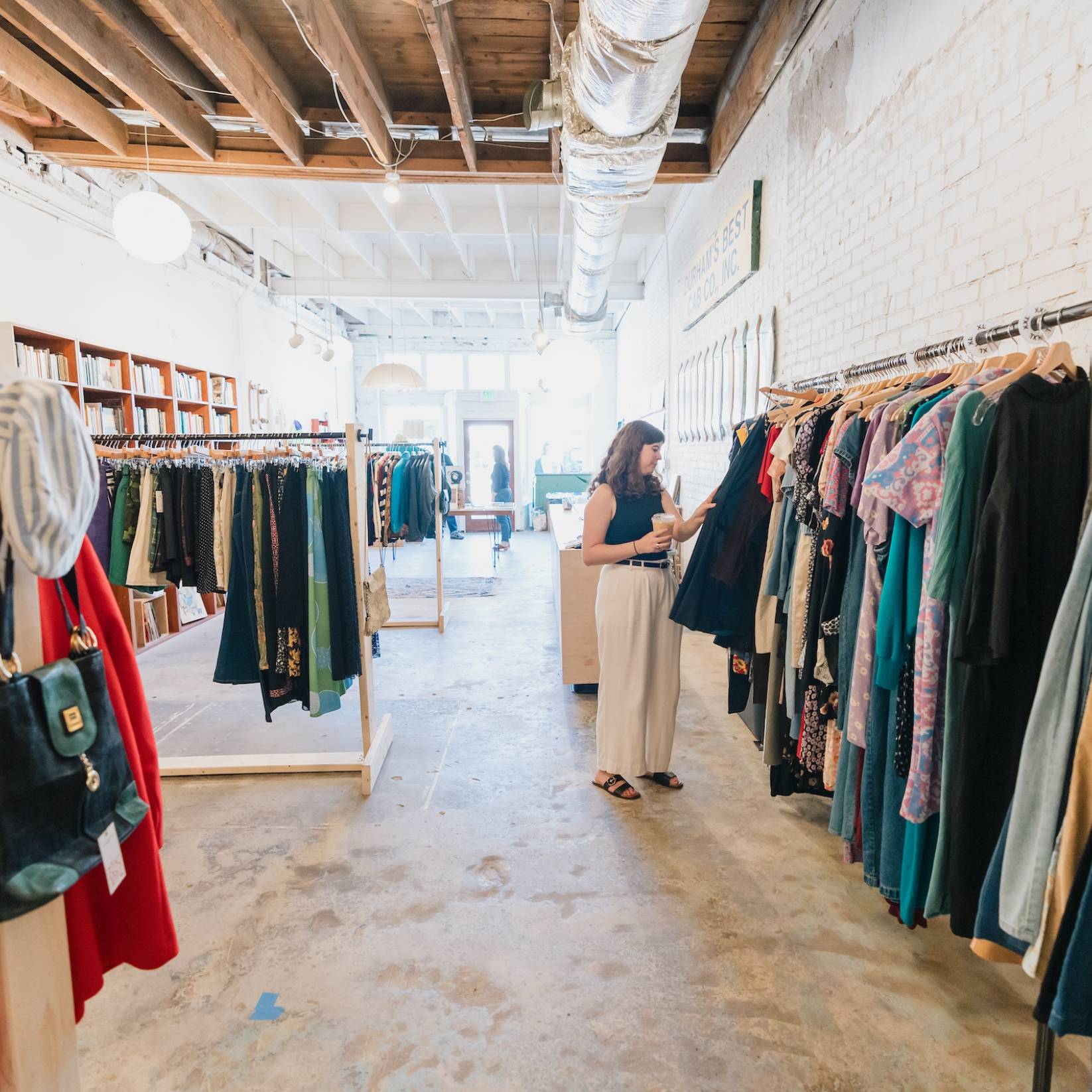 A woman browses the racks in a Durham, NC vintage clothing store
