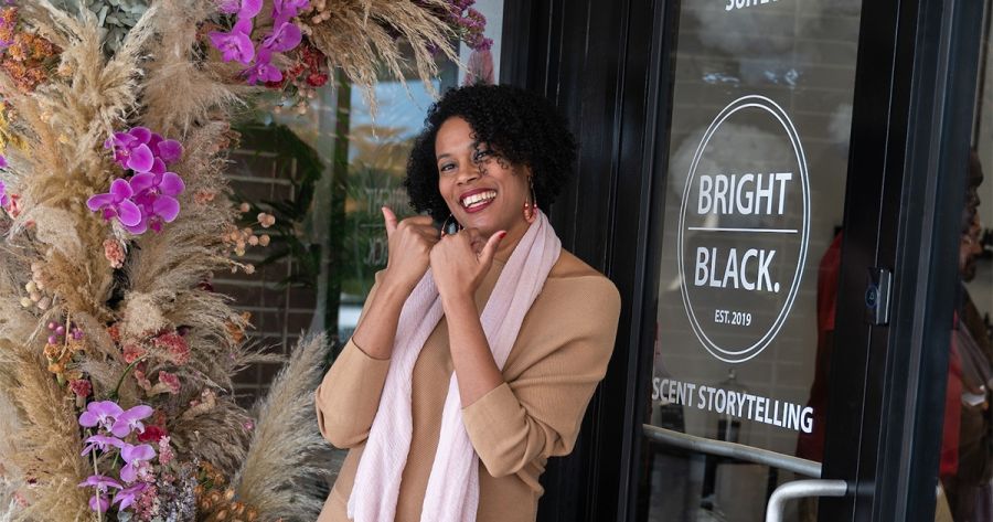 The owner of Bright Black shows the "Love Durham" bull horns in front of the store.