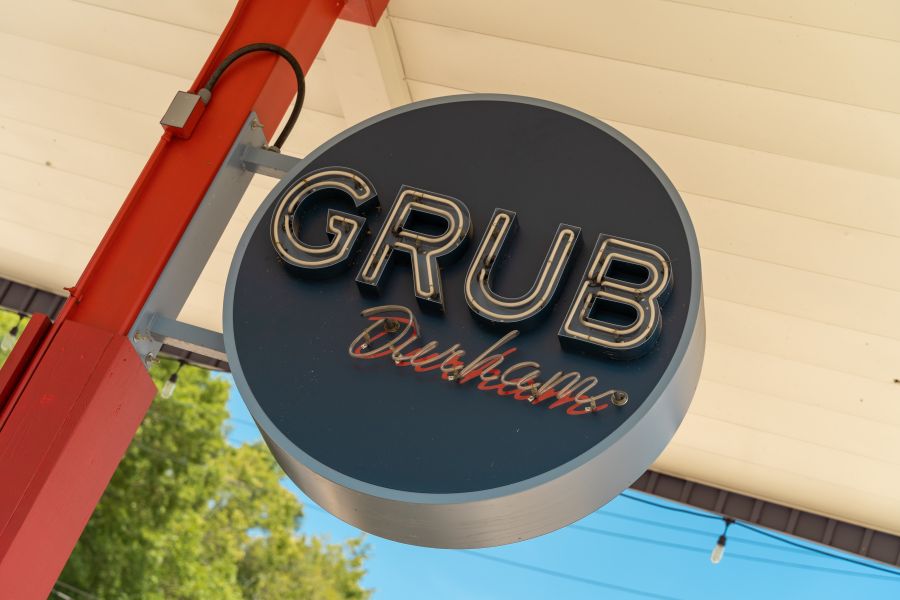 The sign for GRUB Durham hangs on a pole in the air, welcoming in guests.