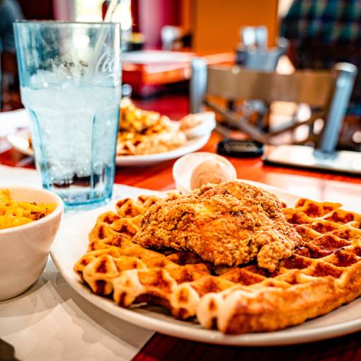 A hot plate of chicken and waffles fresh from the kitchen adorn a plate at Dame's Chicken and Waffles in Durham, NC.
