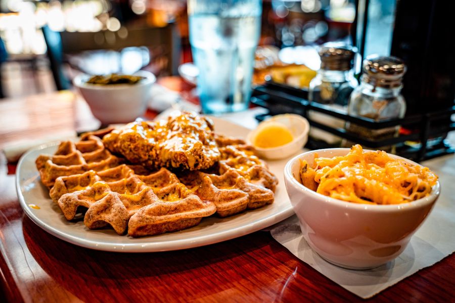 A crispy fried chicken cutlet sits on a fluffy golden waffle at Dame's Chicken and Waffles.