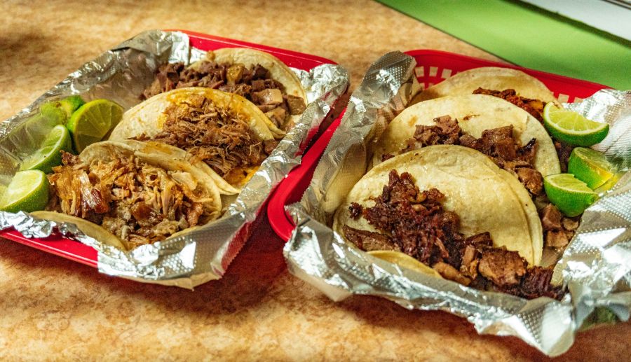 Two trays of tacos sit steaming on a table at Super Taqueria in Durham, NC.