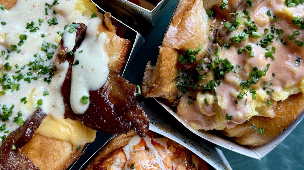 Four colorful, saucy dishes sit on a table at Aaktun in Durham, NC.
