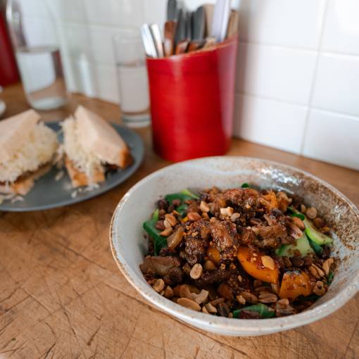 A bowl of noodles sits in front of a plated sandwich on the counter at Rose's in Durham, NC.