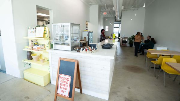 White walls surround the interior of Hatch Burritos where customers enjoy breakfast.