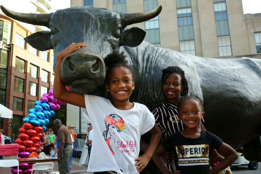 Children smile for a photo with Major the Bull.