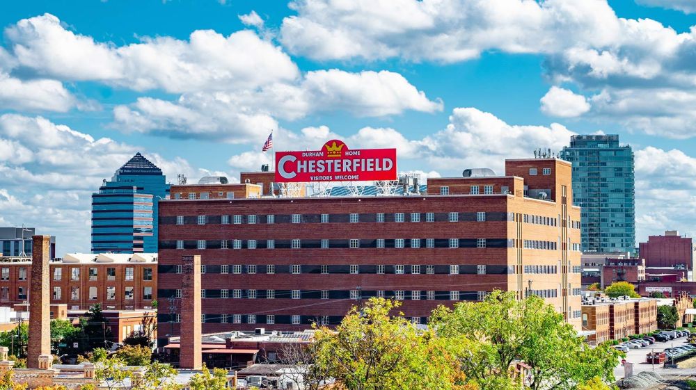 Downtown Durham skyline with the Chesterfield's red "Visitors Welcome" sign prominent in the foreground