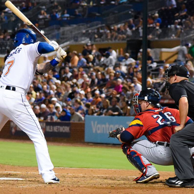 A Durham Bulls player stands poised with his bat at home plate, ready to knock the ball out of the park.