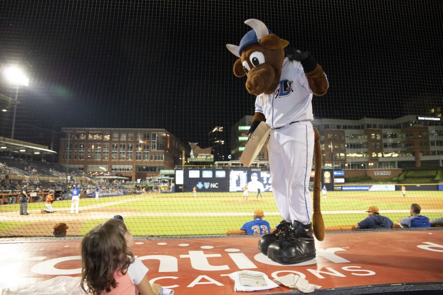 Wool E Bull looks down at a child at a Durham Bulls game.