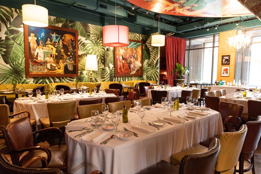 Open tables await customers in the ambient lighting of Parizade in Durham, NC.