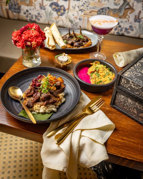 A spread of Indian dishes wait on a table at Cheeni to be enjoyed by guests.