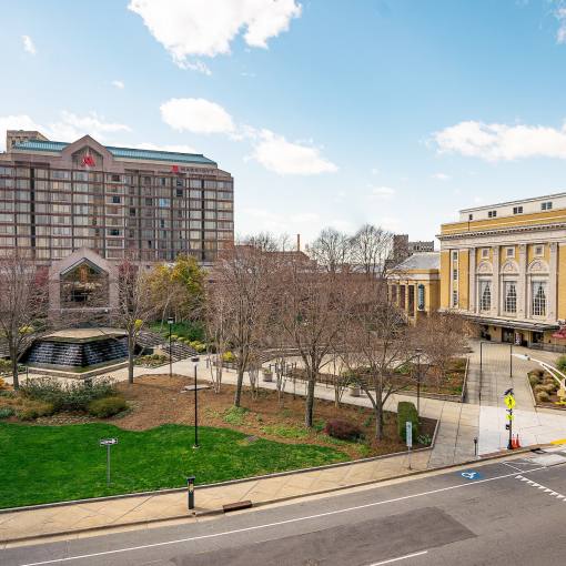 Clouds roll through a blue sky over the yellow facade of the Carolina Theatre.