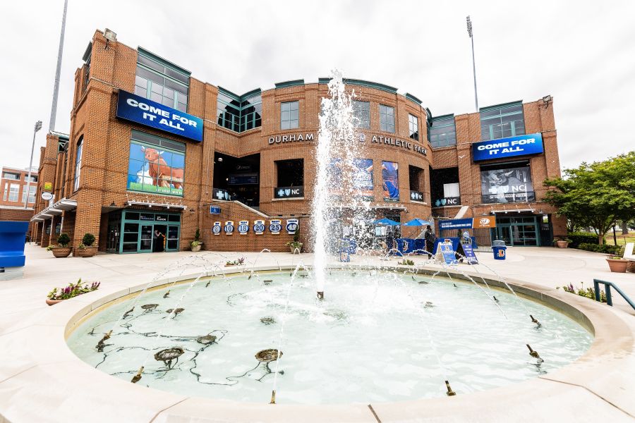 A fountain shoots water high in the air in front of the Durham Bulls Athletic Park.