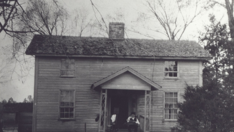 An old black and white photo shows the Duke Homestead house in its original form.