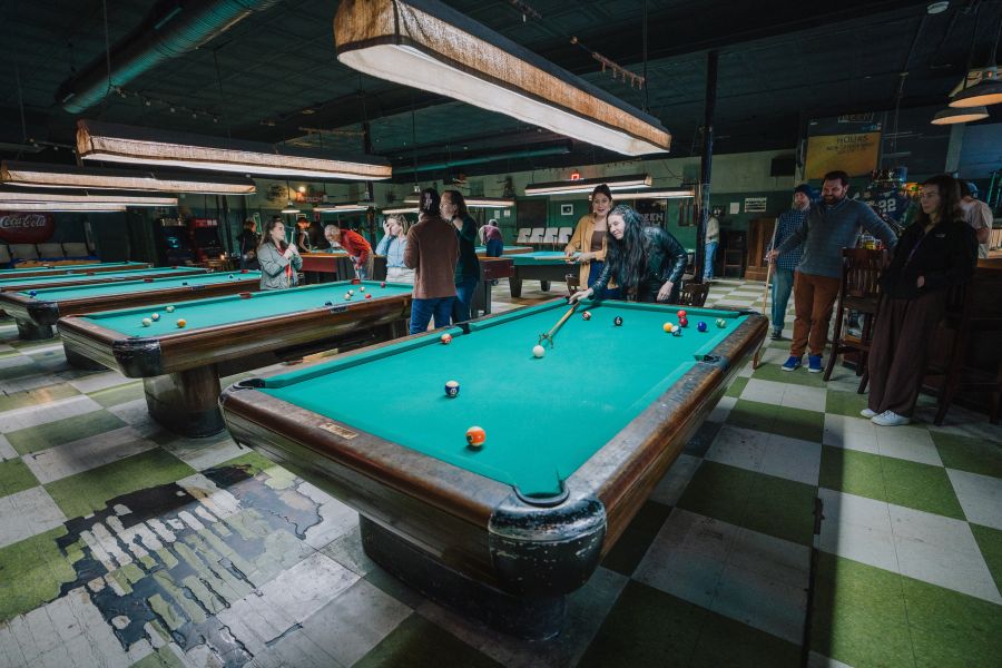 Guests stand around a pool table at The Green Room in Durham, NC.