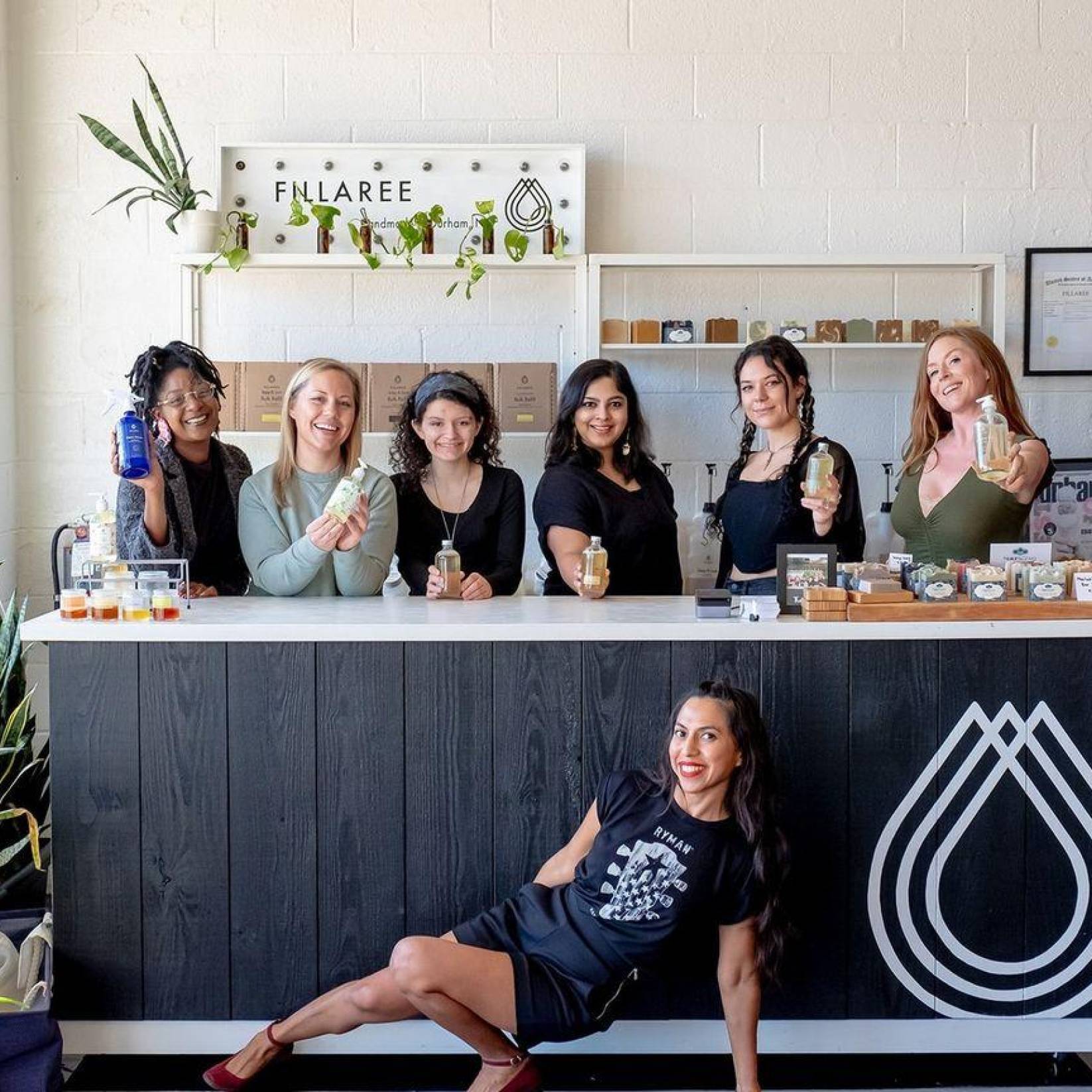 Workers pose with products in front of a counter at Fillaree in Durham. The store is airy and bright with plants and shelves