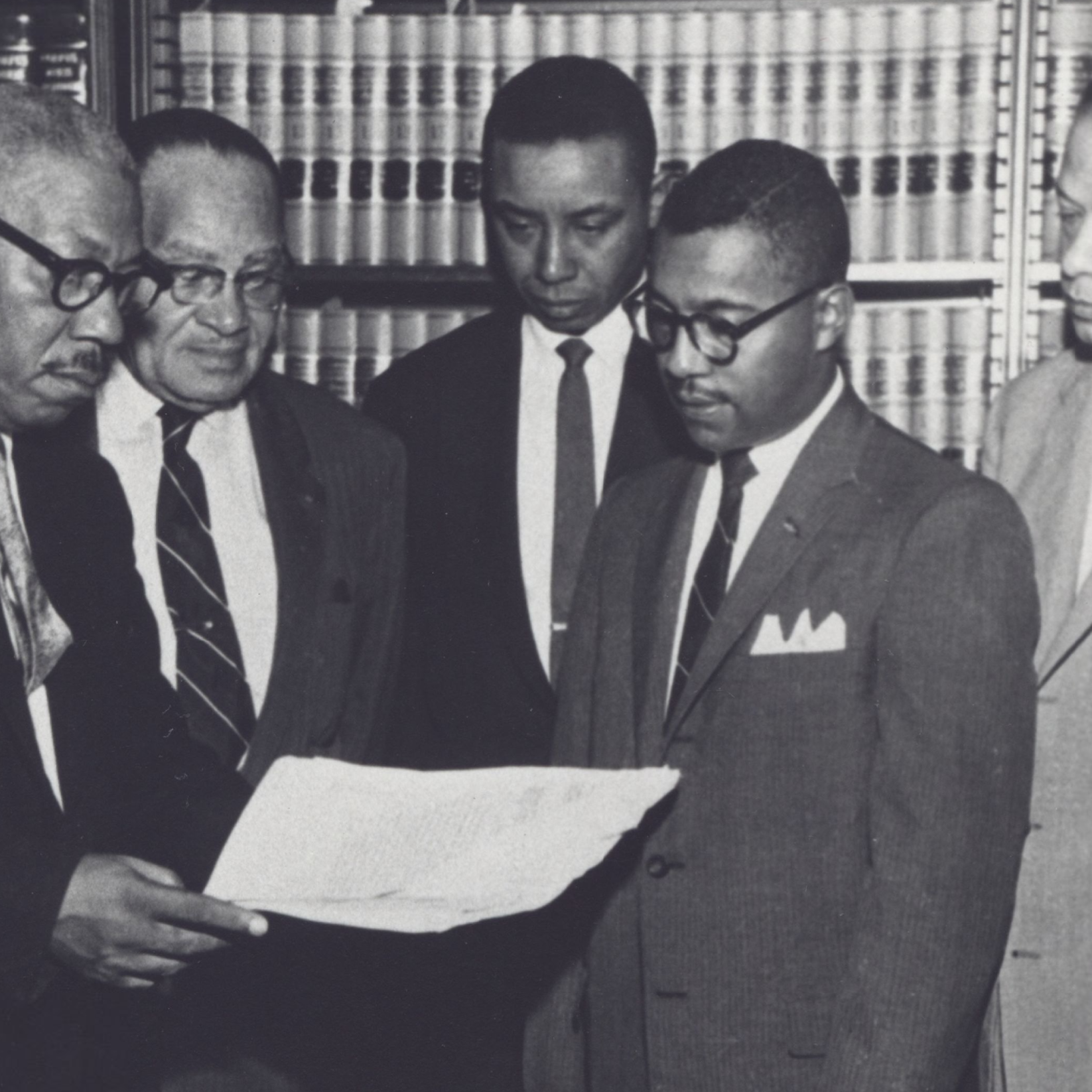 Judge Floyd McKissick stands in a black and white photo with other men.