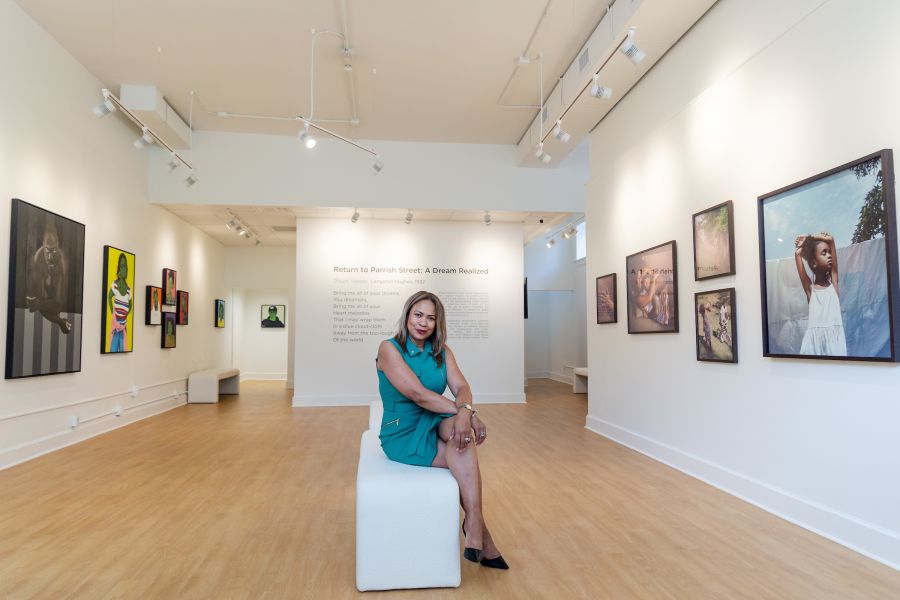 Portrait of Ella West Gallery founder Linda Shopshire in her gallery, a bright space with white walls and lots of art.