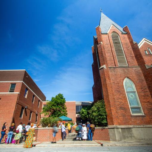A brick church with a Gothic Revival-style against a clear blue sky in Durham, NC.