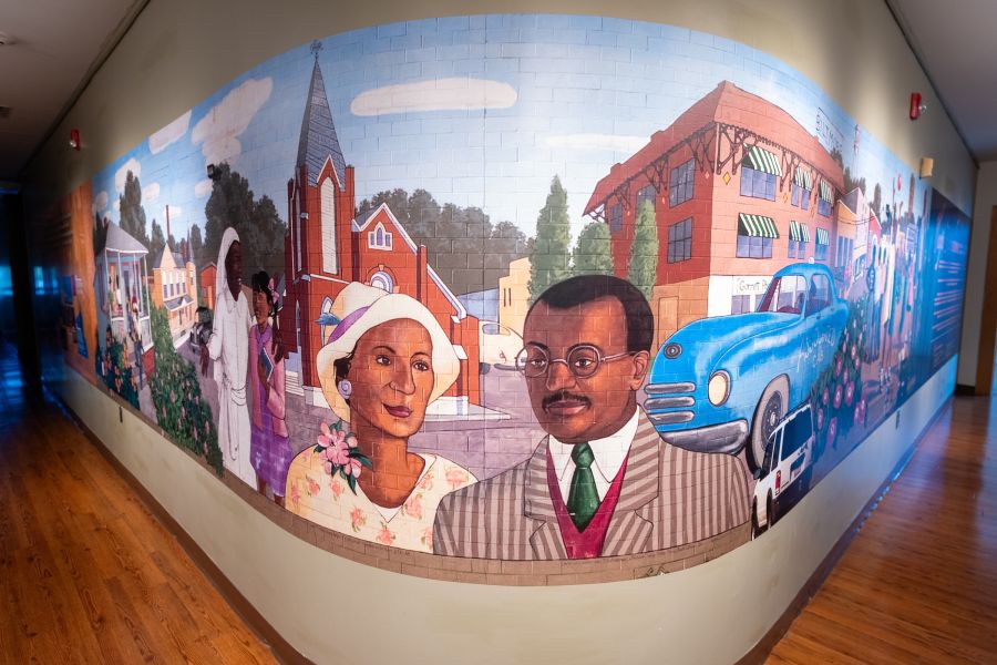 A large mural honoring Black Wall Street adorns an inside wall at Hayti Heritage Center.