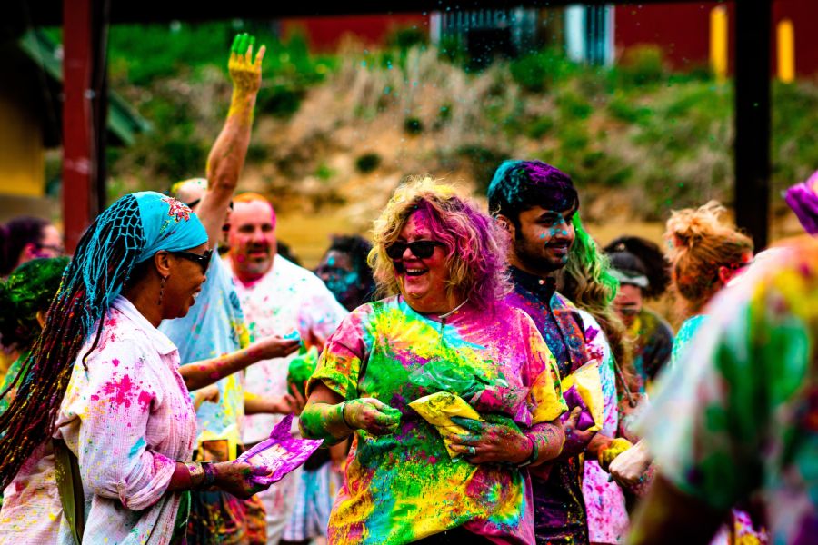 People participating in a color festival at a Holi Celebration. They're covered in brightly colored powder.