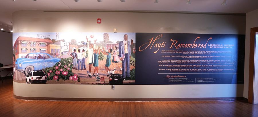 A wall features a re-created mural of historic Hayti, and information about the original mural and the effort to preserve it.