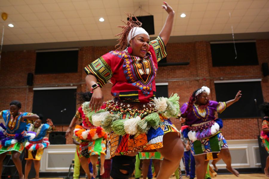 A performer smiles while they dance at Kwannzaa Fest in Durham.
