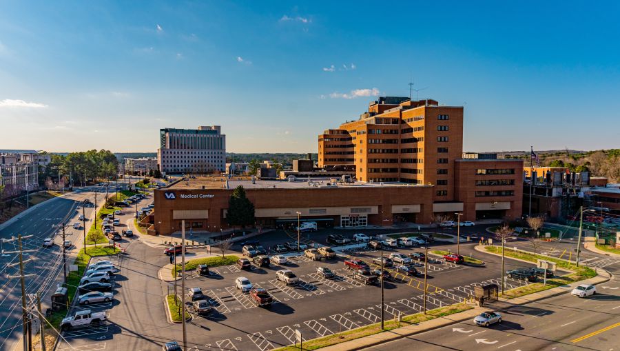 Cars park outside of the Durham VA Medical Center on a sunny day.