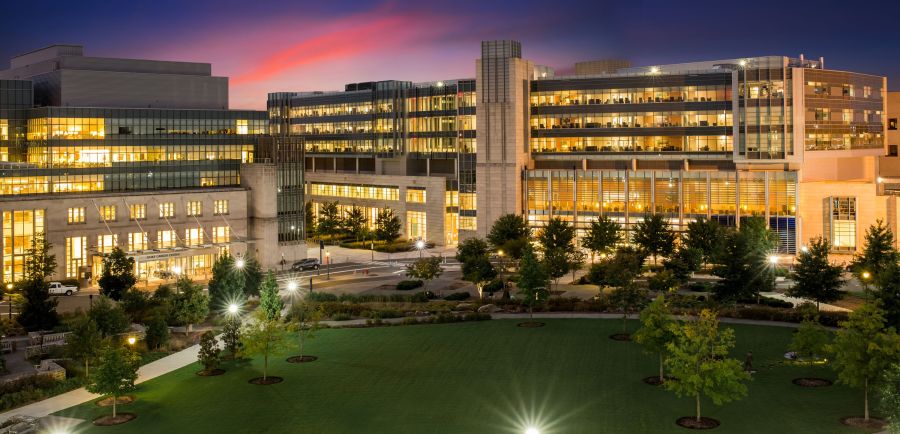 The lights of Duke University Health System Campus shine bright under a night sky.