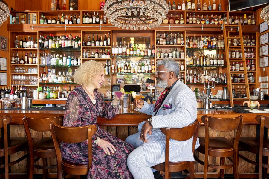 A couple cheers drinks at the bar at NanaSteak in Durham, NC.