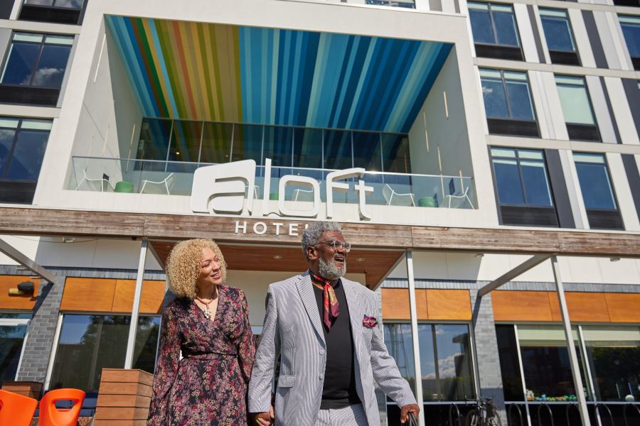 A couple walk out of Aloft hotel in Downtown Durham.