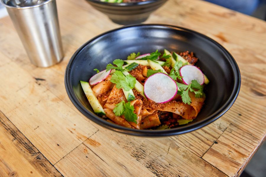 A plate of vegan Biang Biang noodles sits on a table at M Kokko waiting to be enjoyed.