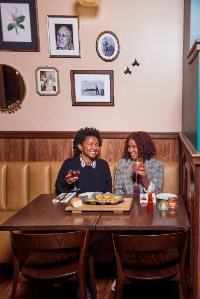 People enjoy cocktails and food inside Seraphine, a Louisanna-style restaurant.