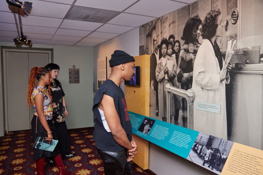 Theatre guests examine a picture at the Confronting Change exhibit at The Carolina Theatre in Durham.