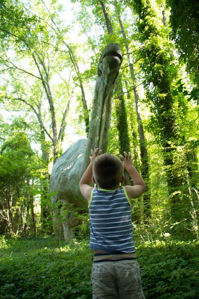 A child stands under Bronto on the Ellerbe Creek Trail in Durham, NC.