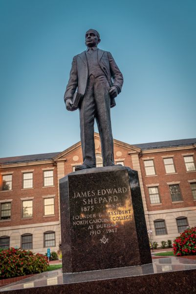 The statue of James E. Shepard stands tall in front of a building on NCCU's Campus.