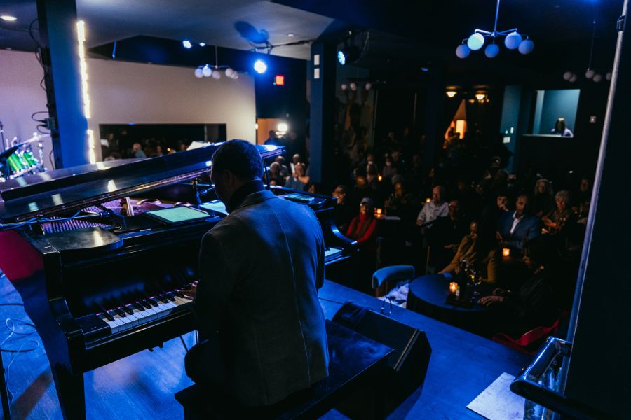 A pianist plays under blue lights for a crowd at Missy Lane's Assembly Room in Durham.