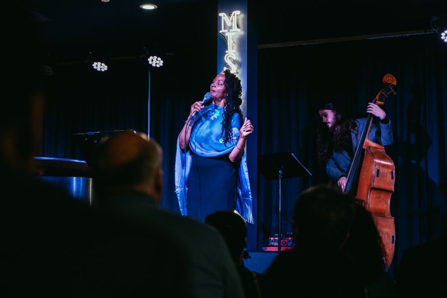 A singer performs on stage in the dim lights of Missy Lane's Assembly Room.